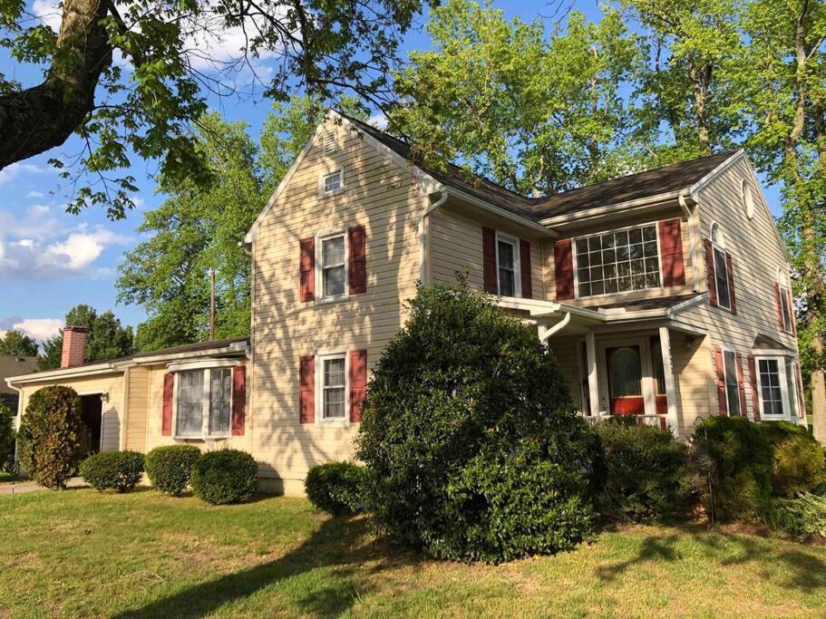 a white house with red shutters on a yard at Peaceful 3BR Home Near SU, Sports Fields, Civic Center, Zoo & Ocean City in Salisbury