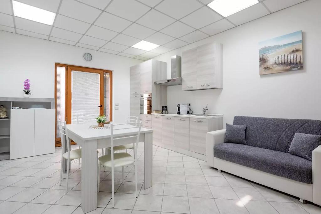 a kitchen and living room with a table and a couch at Saint Simplicio House in Olbia
