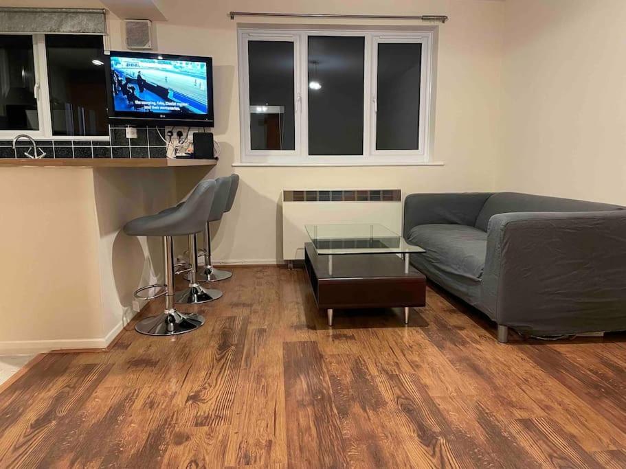 a living room with a couch and a table at London flat next to DLR station with free parking in London