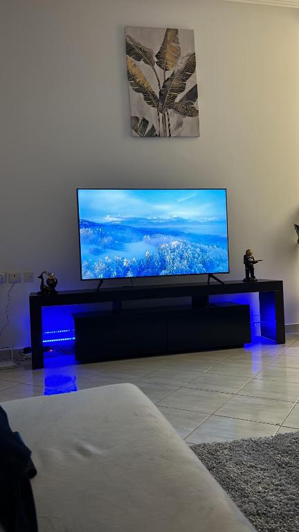 a living room with a flat screen tv on a table at Appartement luxueux à Agdal près de la gare in Rabat