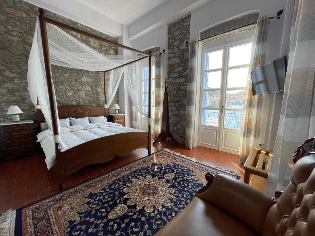 1 dormitorio con cama con dosel y ventana en Anamar Symi Residences, en Symi