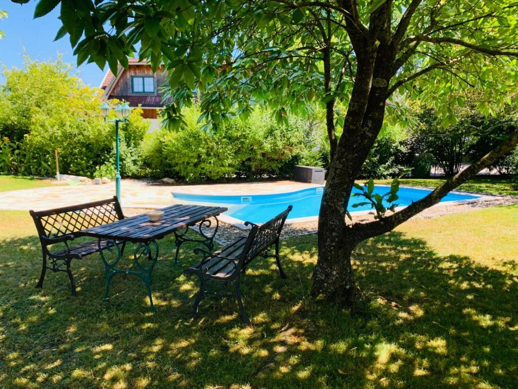 a picnic table and chairs under a tree next to a pool at Albergue Haid 