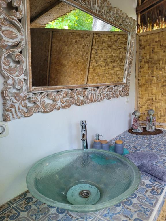 La salle de bains est pourvue d'un lavabo et d'un grand miroir. dans l'établissement Gili Matiki, à Gili Air