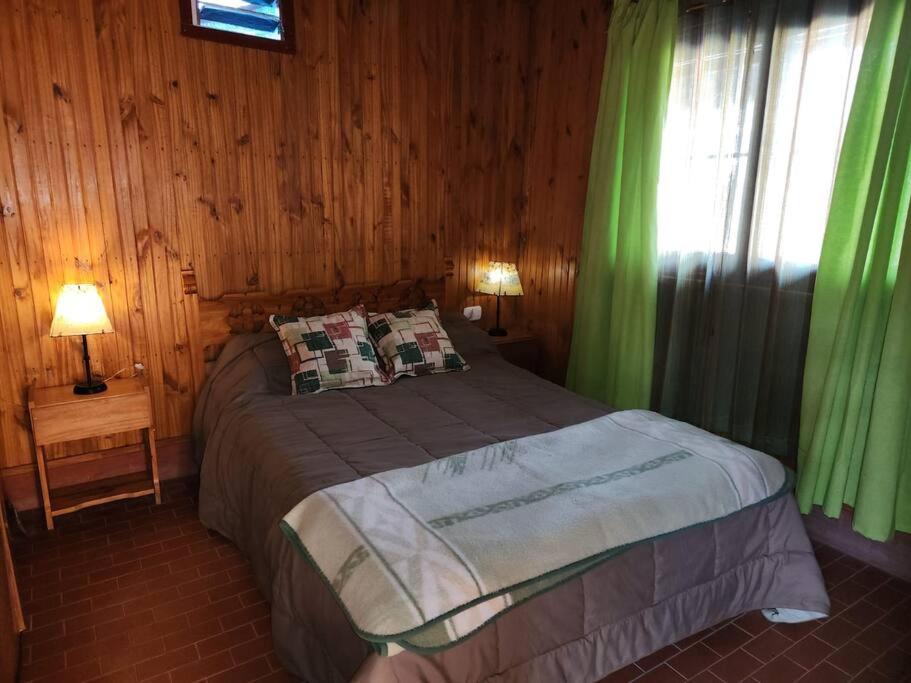ルハン・デ・クージョにあるLa cabaña de Tito.のベッドルーム1室(緑のカーテンと窓付きのベッド1台付)