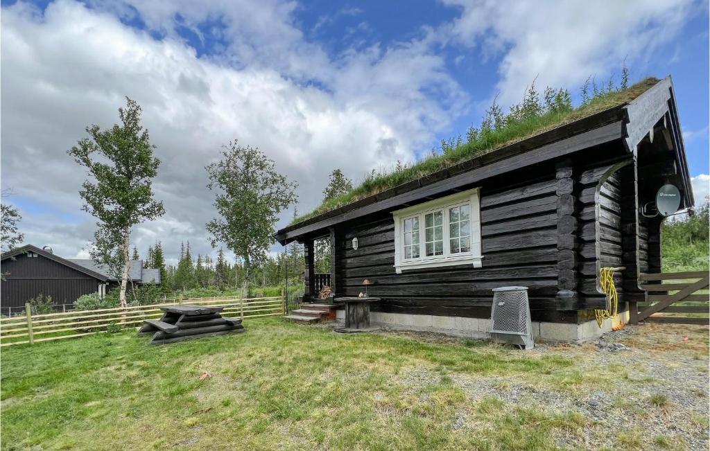 a log cabin with a window and a grass yard at Stunning Home In Nord-torpa With Kitchen in Nord Torpa