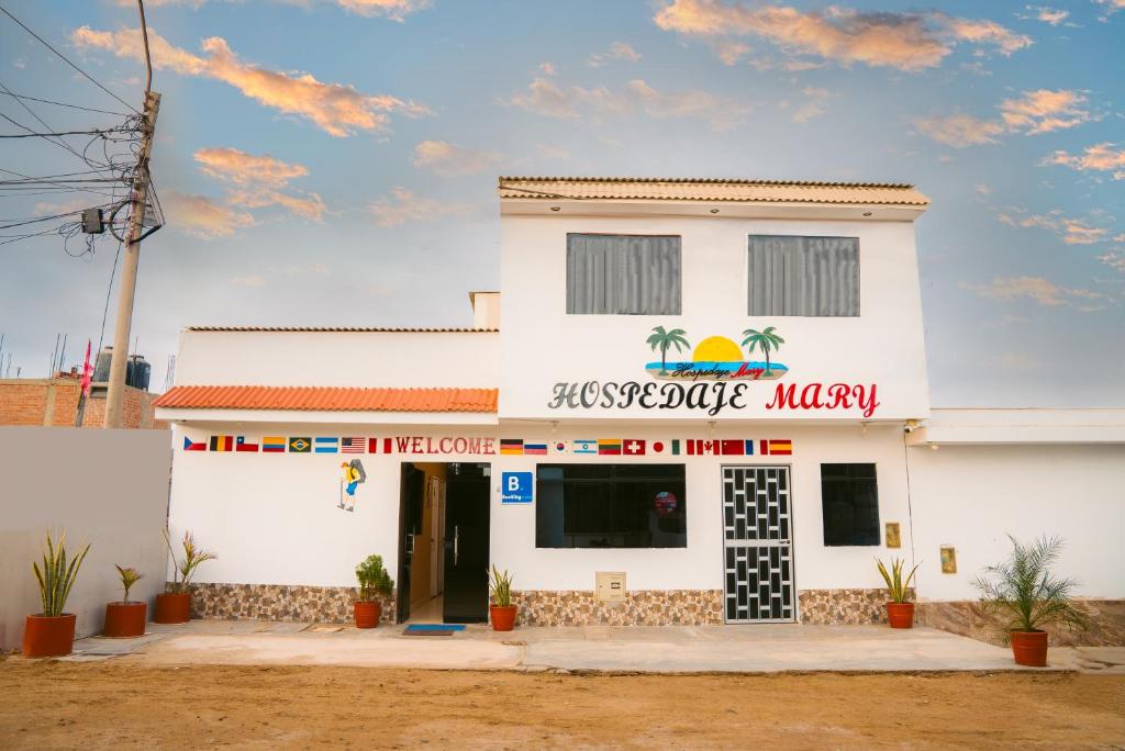 un edificio blanco con un cartel. en Hospedaje Mary, en Paracas