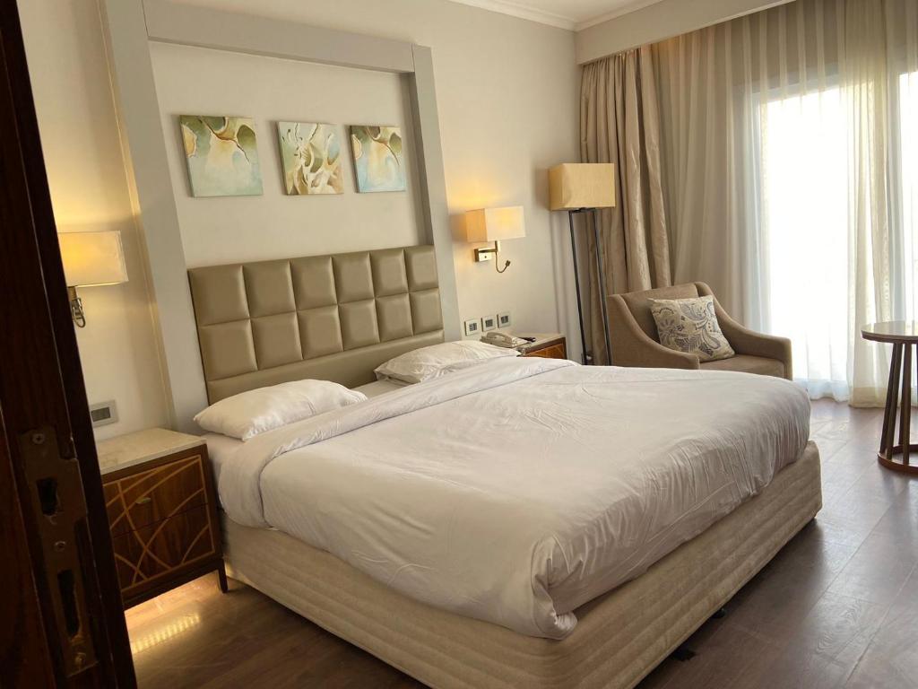 a hotel room with a large bed and a chair at Hotel studio in Sharm El Sheikh
