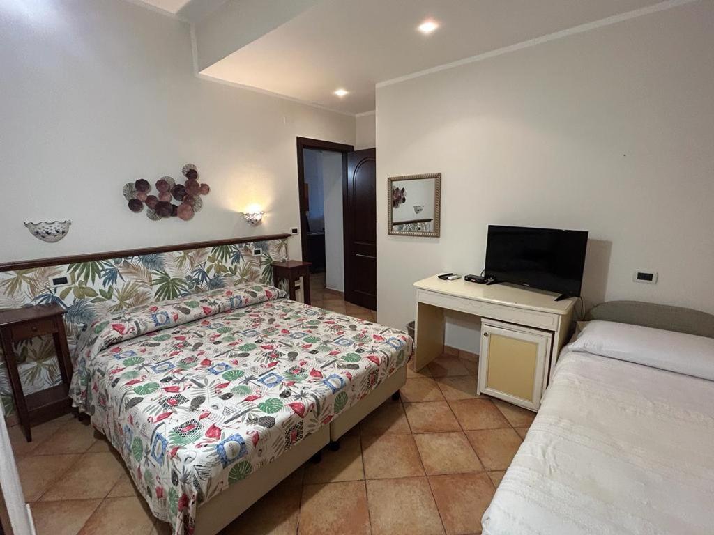 1 dormitorio con 1 cama y escritorio con TV en Dormo Da Lia Borgo San Nicola, en Mandra Capreria