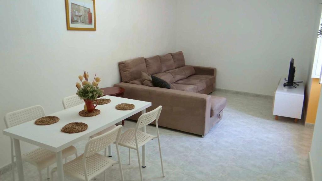 sala de estar con sofá, mesa y sillas en Casa Lore Casa para 5 en Lariño, en Lariño