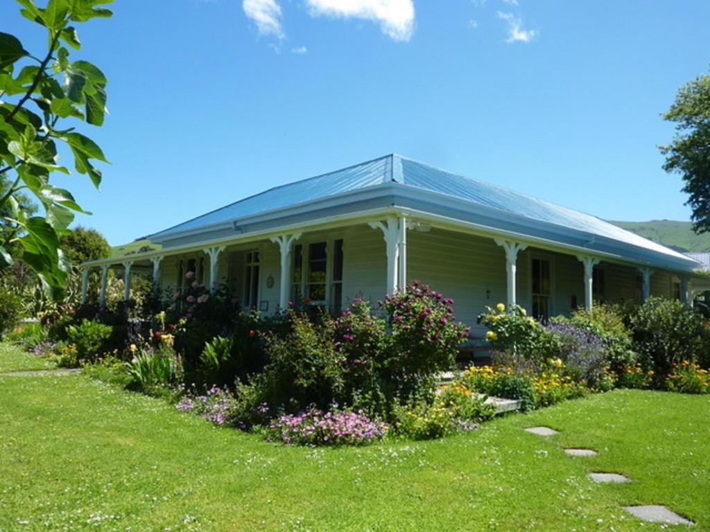 una casa con un jardín delante de ella en Halfmoon Cottage en Akaroa