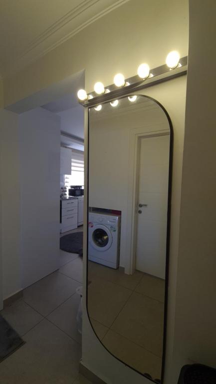 a mirror in a room with a washing machine and lights at Anemon Residence in Alanya