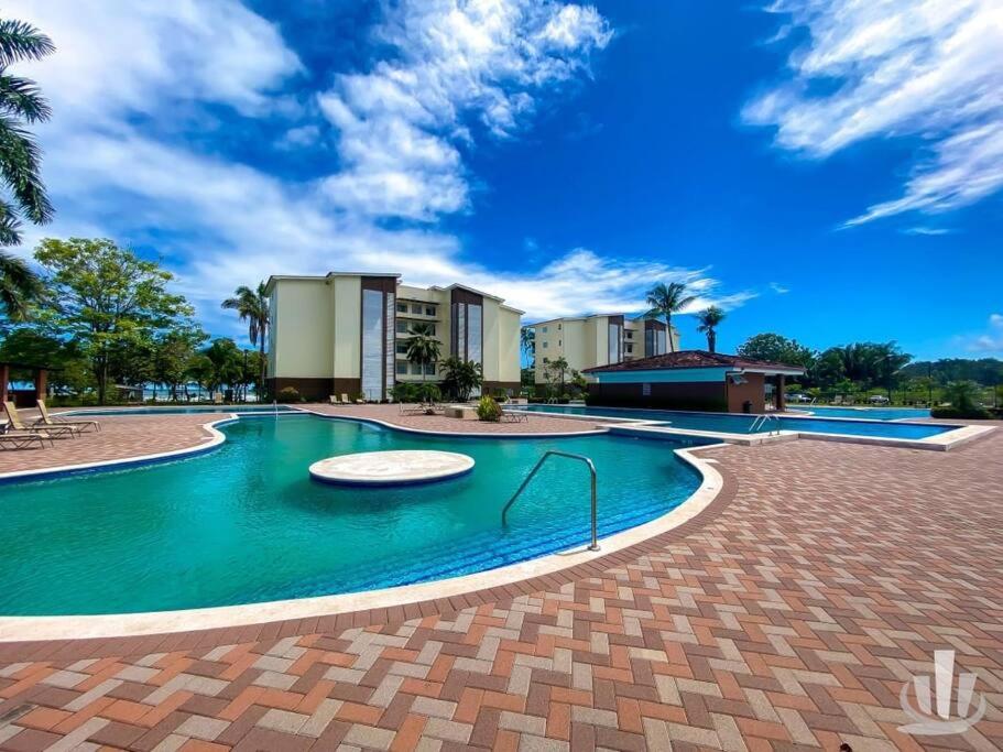 una piscina en un complejo con cielo azul en Condo Jaco bejuco frente al mar y casa con piscina, en Jacó