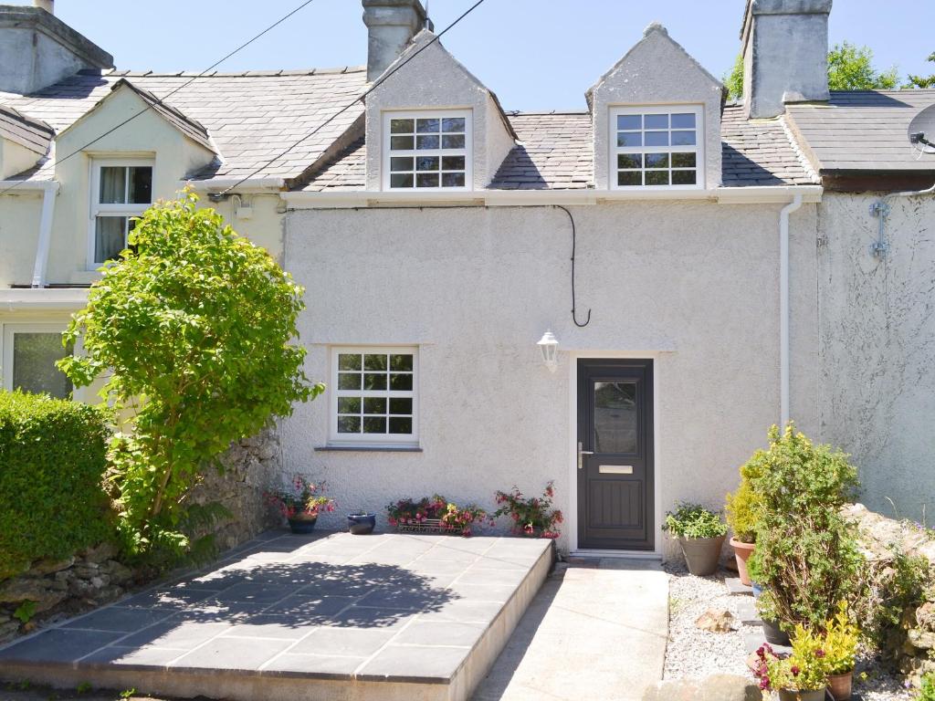 a white house with a black door at Ty Bobbet in Amlwch