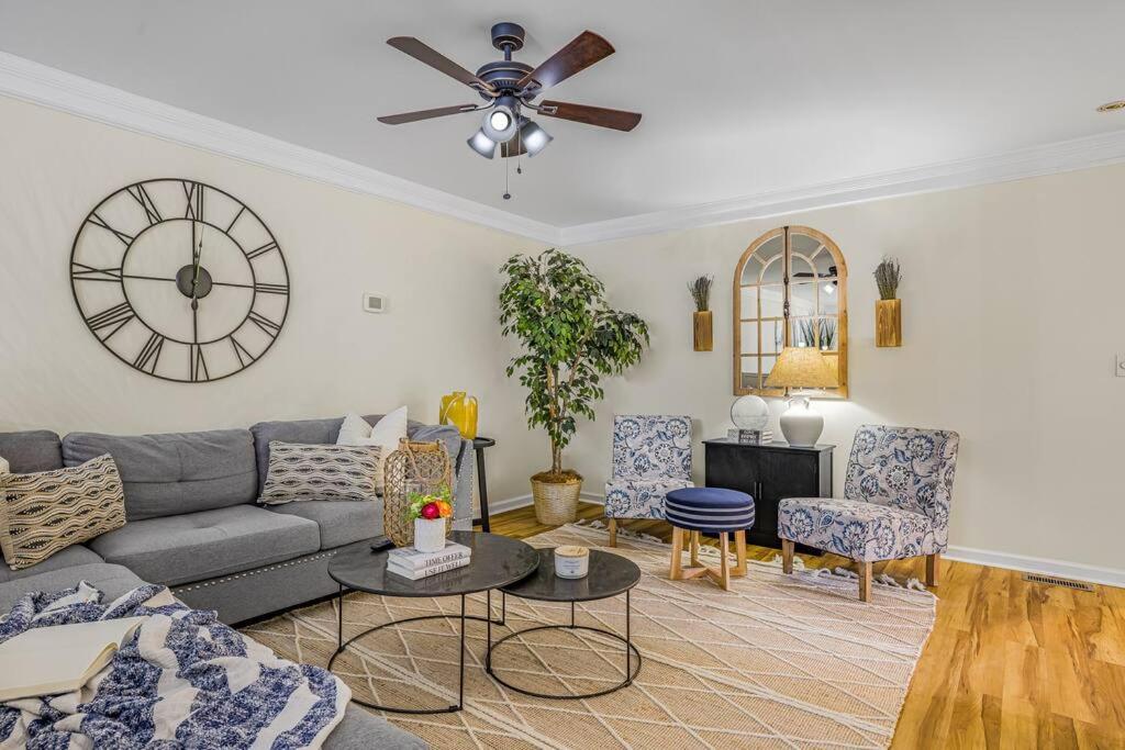 a living room with a couch and a clock on the wall at Ultimate Retreat @ Papermill Rd in Newark