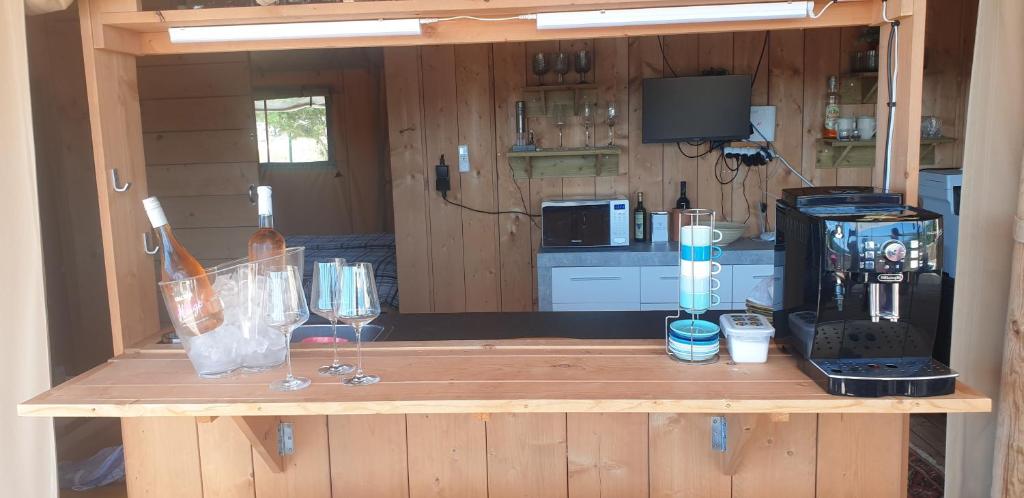a wooden counter in a kitchen with wine glasses on it at Larah Land 4 Star Glamping Yala Lodge plus kids lodge in Šimuni