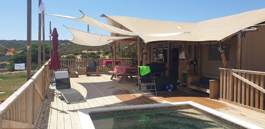 a wooden deck with a swimming pool and a tent at Larah Land 4 Star Glamping Yala Lodge plus kids lodge in Šimuni