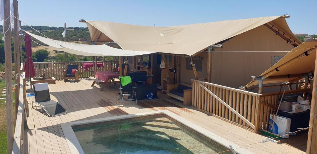 a deck with a canopy over a swimming pool at Larah Land 4 Star Glamping Yala Lodge plus kids lodge in Šimuni