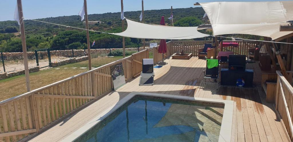 a balcony with a swimming pool and a fence at Larah Land 4 Star Glamping Yala Lodge plus kids lodge in Šimuni