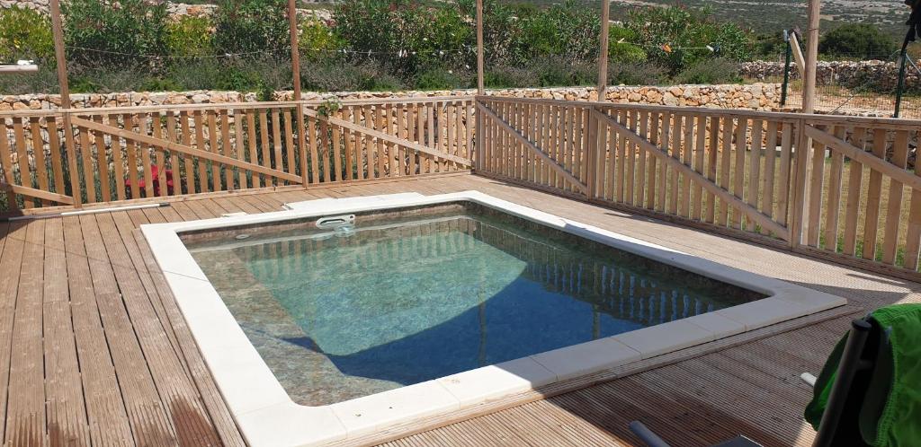a swimming pool on a deck with a wooden fence at Larah Land 4 Star Glamping Yala Lodge plus kids lodge in Šimuni