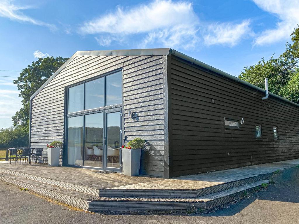 una pequeña casa con una gran puerta de cristal en Yew Tree Barn - Hw7737, en Usk