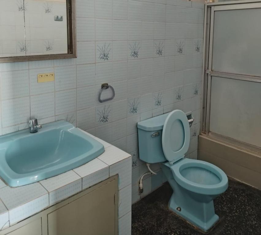 a bathroom with a blue toilet and a bath tub at Piura Eterno Calor in Piura