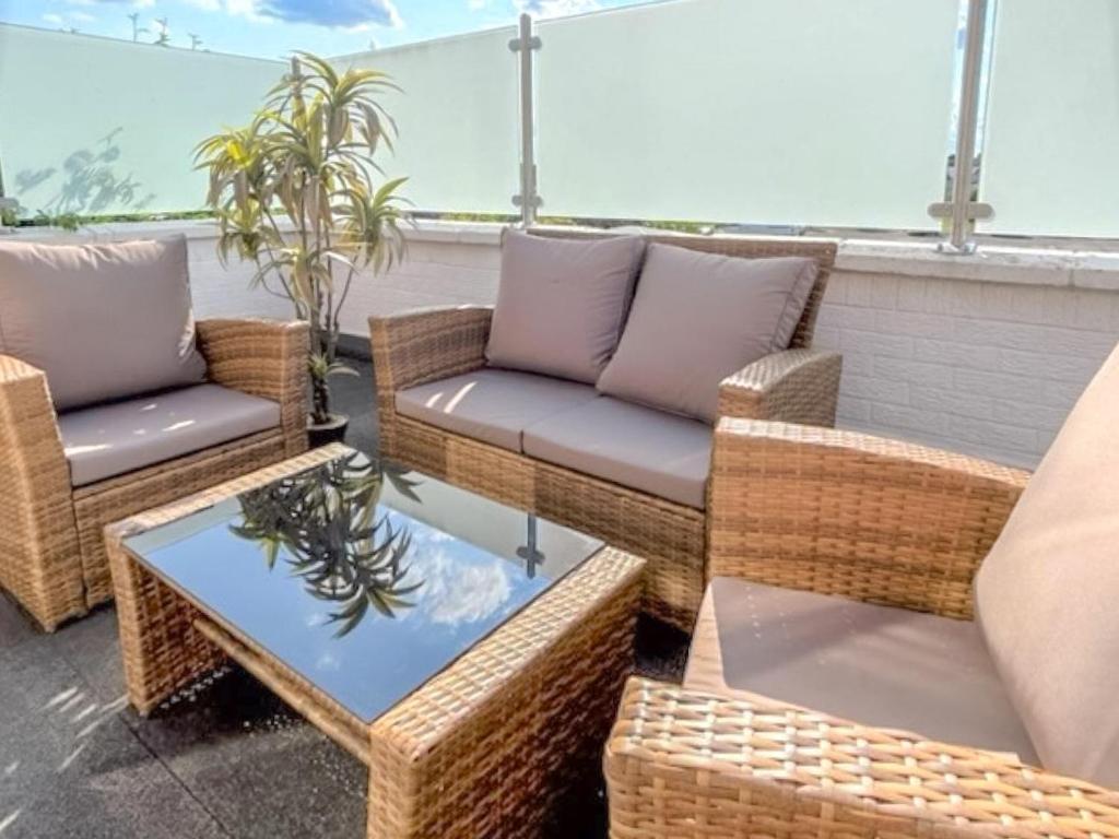 a patio with wicker chairs and tables on a balcony at New Trend in Chapel Saint Leonards