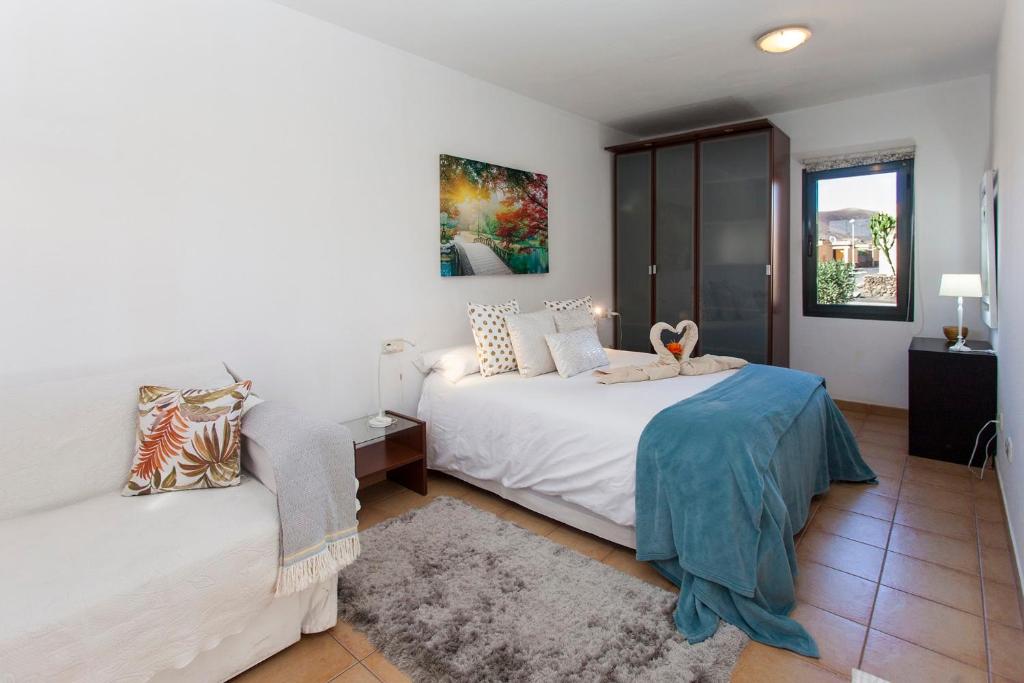 コラレホにあるVivienda Vacacional Orquideaの白いベッドルーム(ベッド2台、窓付)