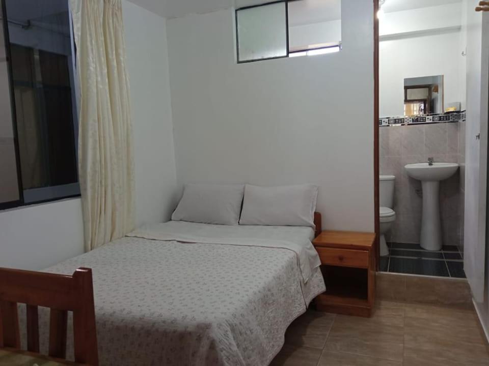 ein kleines Schlafzimmer mit einem Bett und einem Waschbecken in der Unterkunft HOSPEDAJE GIMAJA in Villa Rica