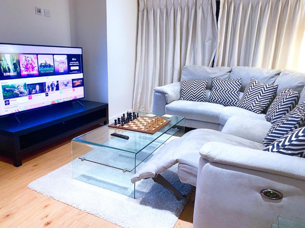 a living room with a couch and a tv at Luxury London flat 5 min walk to Tube Underground in Hendon
