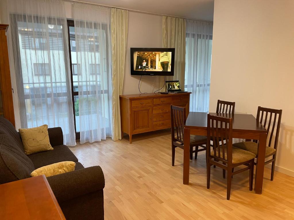salon ze stołem, krzesłami i telewizorem w obiekcie Apartament Dominikański Oliwa w Gdańsku