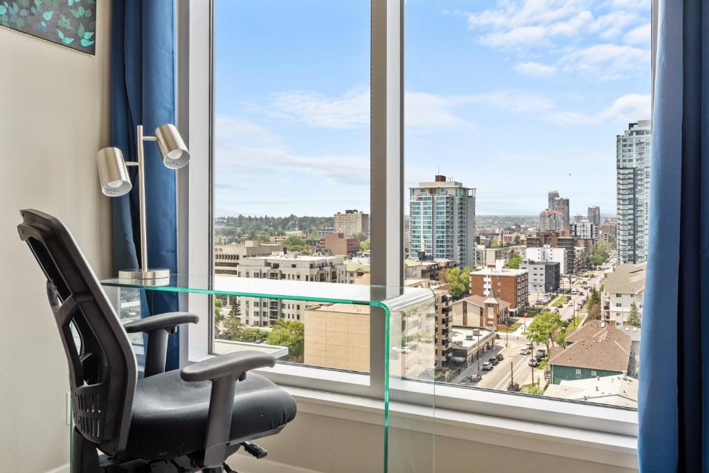 a desk with a chair in front of a window at City Centre Retreat - 1BR Condo with Desk in Calgary