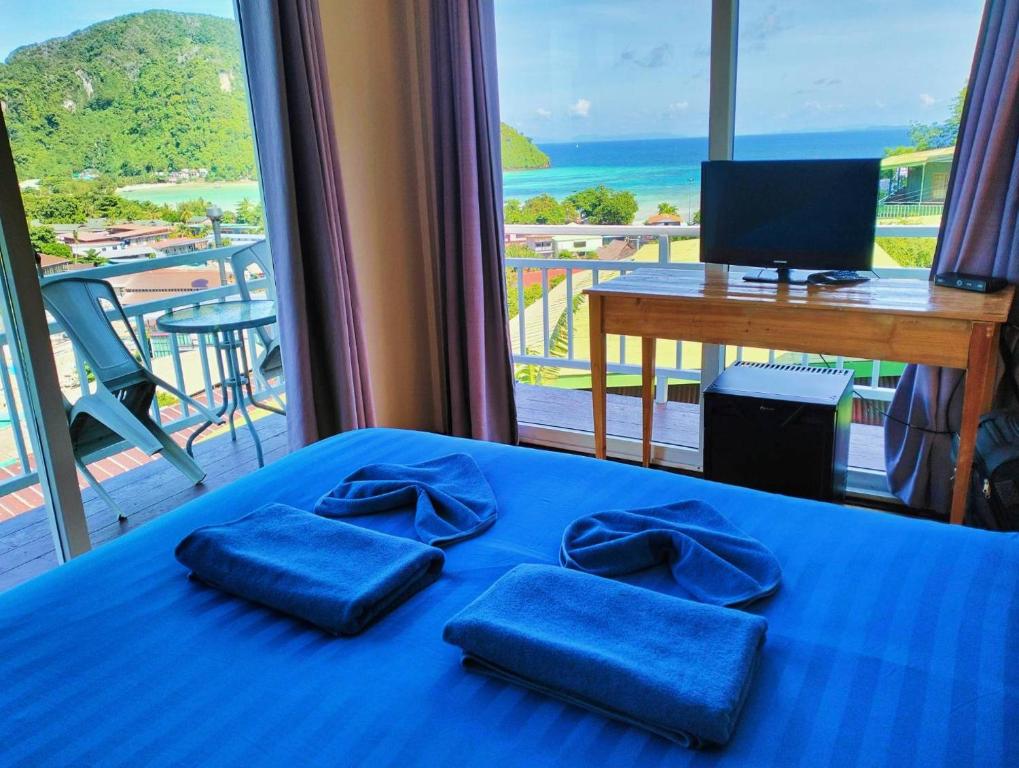 a bedroom with a blue bed with a view of the ocean at Blue View House Phi Phi in Phi Phi Don