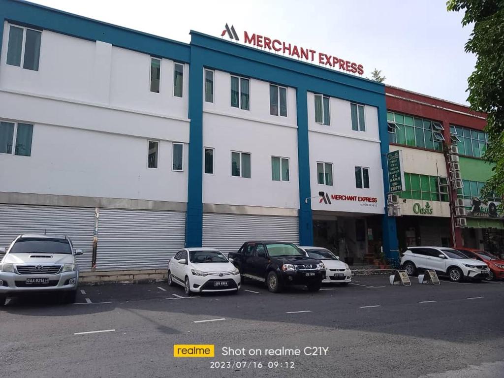 a building with cars parked in a parking lot at Merchant Express Bintulu in Bintulu
