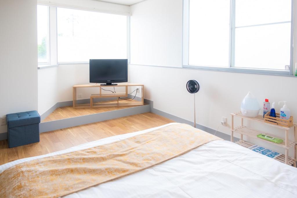 a bedroom with a bed and a tv in it at Hotel Lucia at Maebashi Akagi in Maebashi