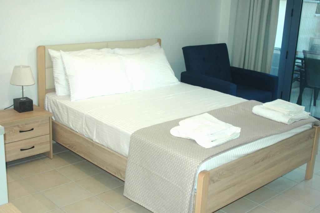 A L' AISE STUDIOS في Apolpaina: غرفة نوم بسرير وكرسي ازرق