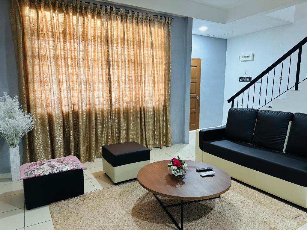 a living room with a couch and a table at Macagawa Homestay in Tawau