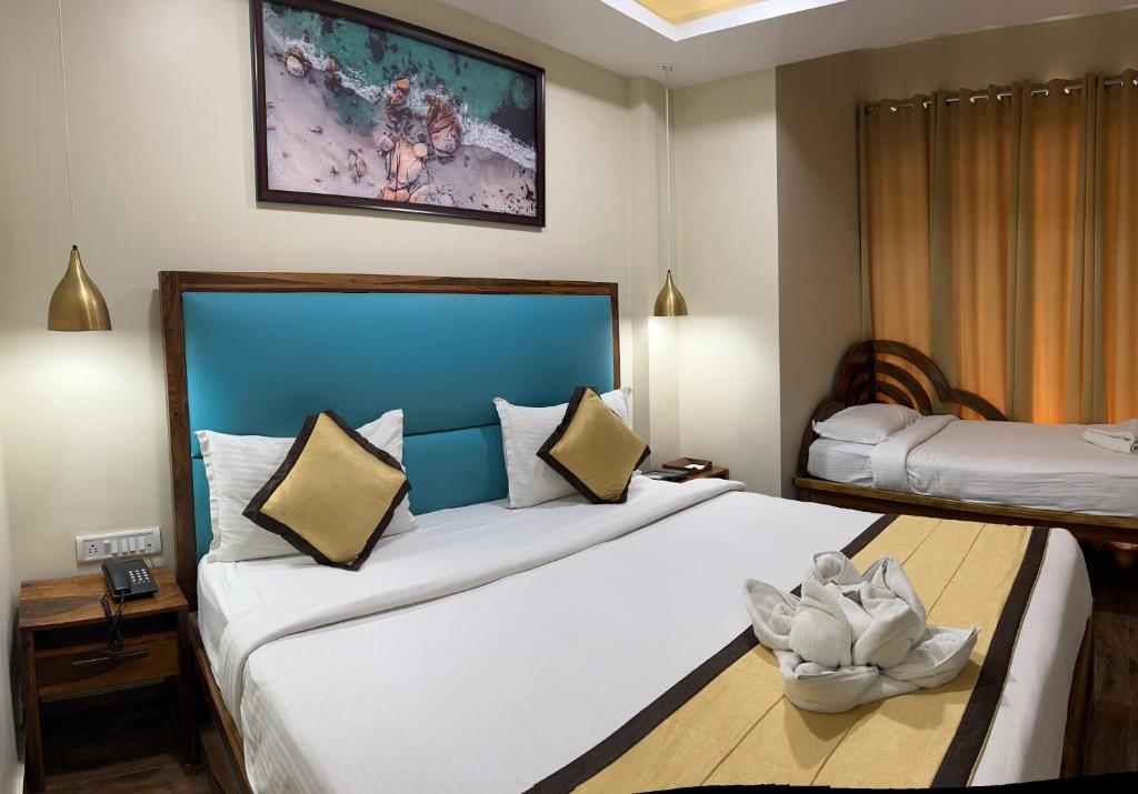 a hotel room with two beds and a painting on the wall at SeaScape Port Blair in Port Blair
