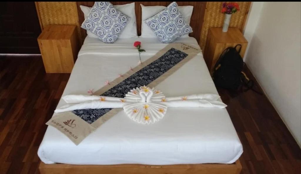 two beds in a room with white sheets at Pai Woodland Resort in Pai