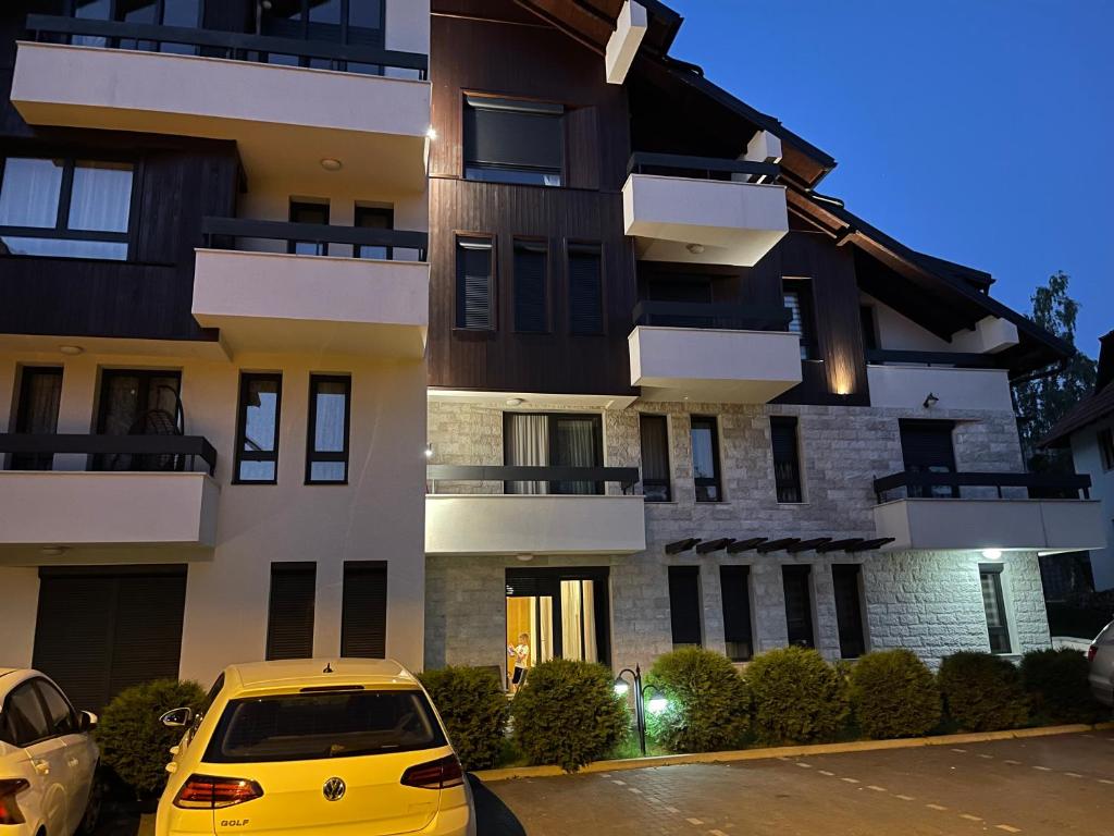 a yellow car parked in front of a building at Apartman Andrija Zlatibor in Zlatibor