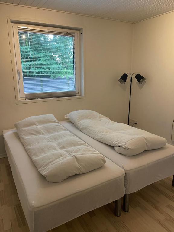 two beds in a room with a window at B&B Stald Saga in Herning