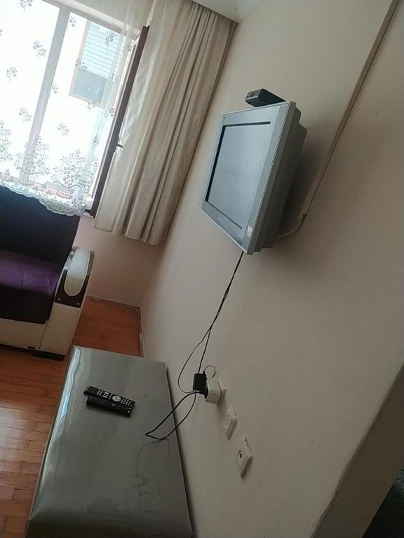 a living room with a tv on the wall and a table at Opium otel in Afyon