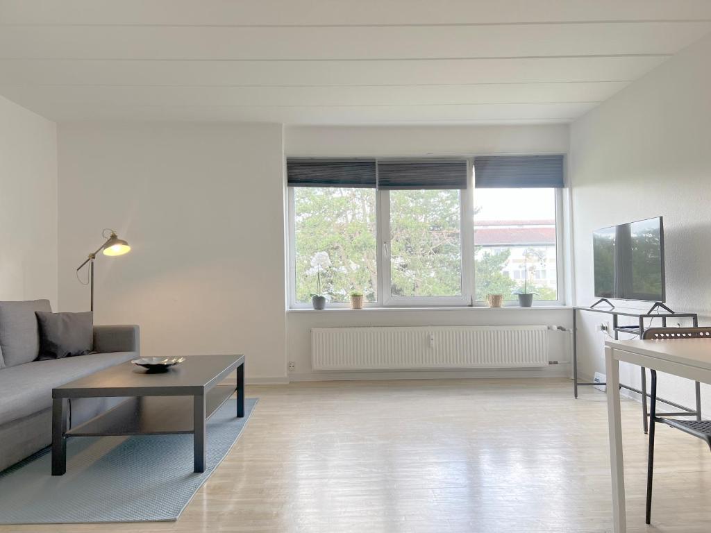 a white living room with a couch and a table at One Bedroom Apartment In Rdovre, Trnvej 41a, in Rødovre