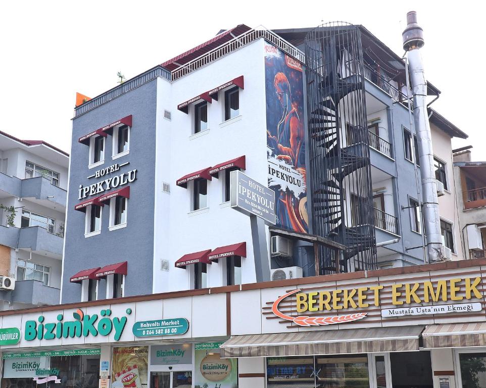 um edifício branco com placas na lateral em Hotel Ipekyolu em Sapanca