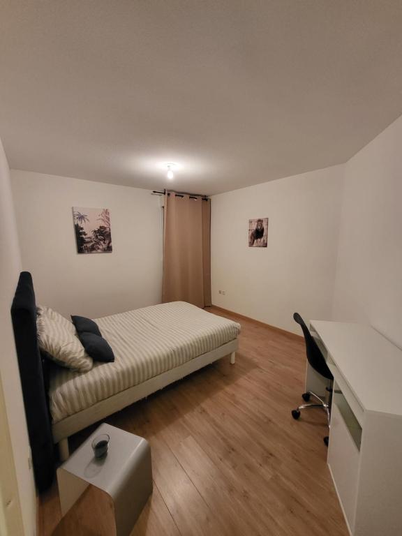 una camera da letto con un letto e una scrivania di T2 climatisé au cœur du pôle Aéronautique,à 8 minutes de l'aéroport a Colomiers