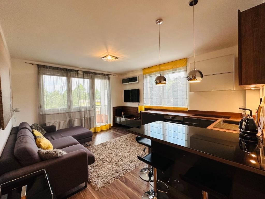 sala de estar con sofá y cocina en B13 Apartman Siófok en Siófok