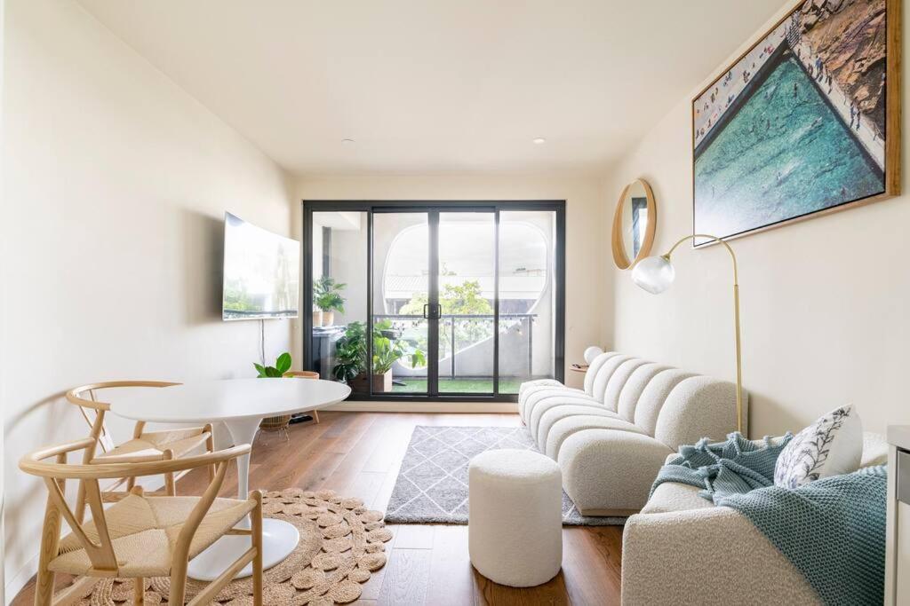a living room with a couch and a table at Beachside flat with free parking in Melbourne
