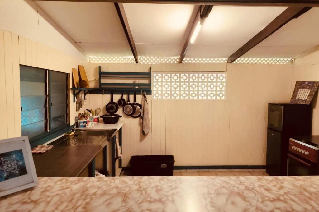 a kitchen with a counter and a sink and a window at Fare Om in Pihaena