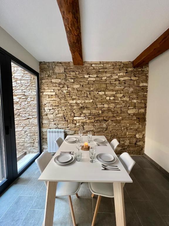 a dining room with a white table and chairs at Cal Teca Rural in Sant Antolí i Vilanova