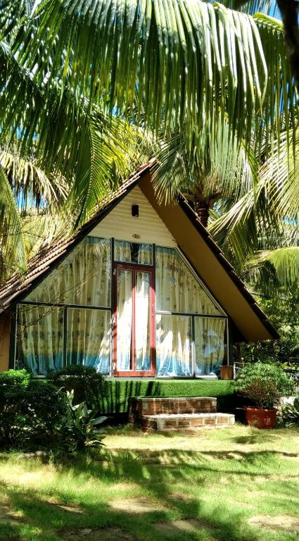 a small house with a window and a palm tree at Phu Nam House - Resort in Phú Quốc