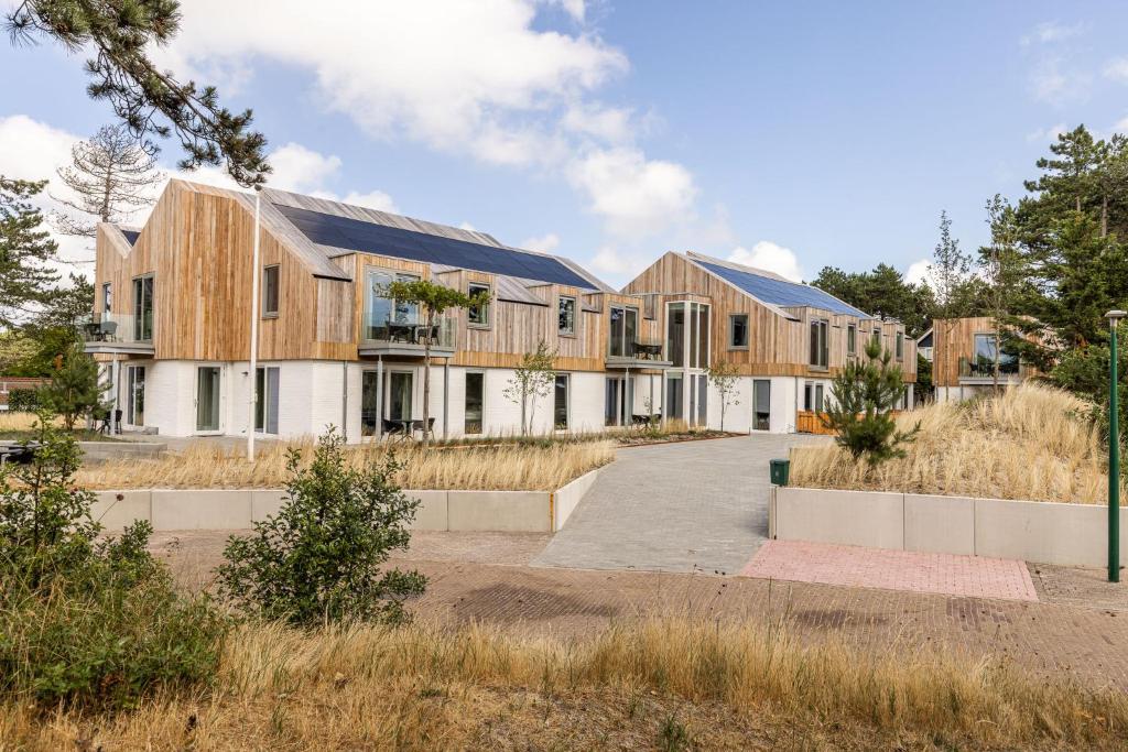 an exterior view of a house with wood at VlieMare Appartementen De Kluut in Oost-Vlieland